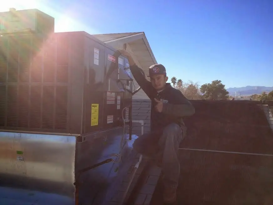 HVAC technician performing AC Tune-Up on a rooftop unit in Garden City